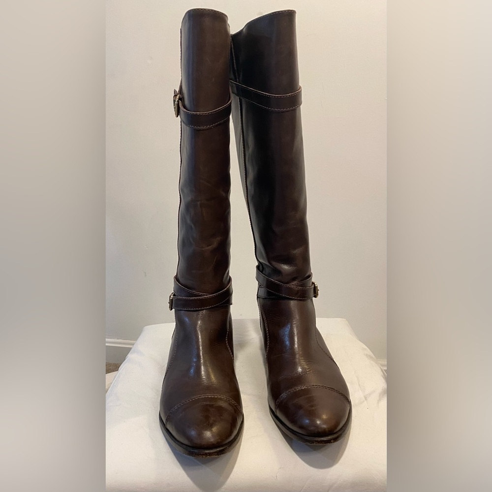 Knee high flat brown leather boots with decorative buckles